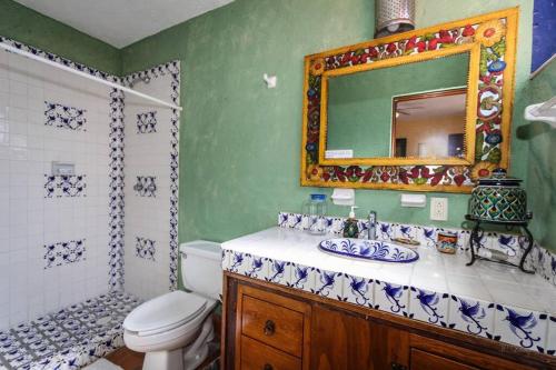 a bathroom with a toilet and a sink and a mirror at Home in San Miguel de Allende. Casita de La Aldea in San Miguel de Allende