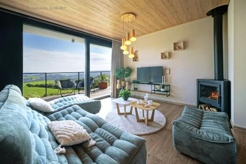 a living room with a blue couch and a fireplace at Gîte Altitude 399 à Trois-Ponts in Basse-Bodeux
