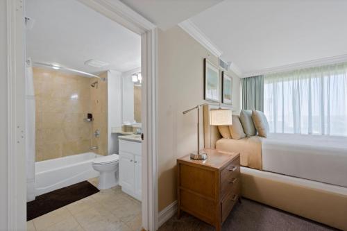 a bathroom with a bed and a tub and a toilet at Marco Beach Ocean Suites in Marco Island