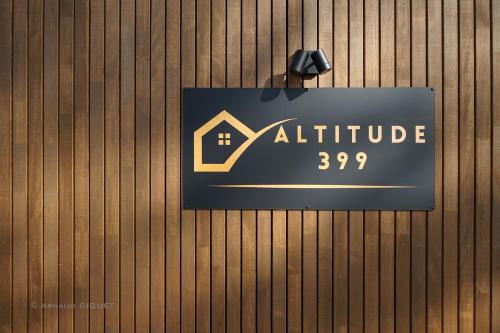 een bord op een houten muur met een huis bij Gîte Altitude 399 à Trois-Ponts in Basse-Bodeux