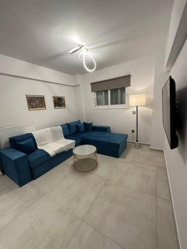 a living room with a blue couch and a tv at Oculus Kolonaki Apt in Athens