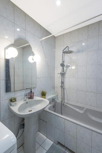 biała łazienka z umywalką i wanną w obiekcie ClickTheFlat Bellottiego Apart Rooms w Warszawie