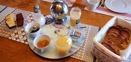 a table with a plate of bread and glasses of orange juice at "La Coustille" Chambres et Table d'Hôtes in Saint-Léger-les-Mélèzes