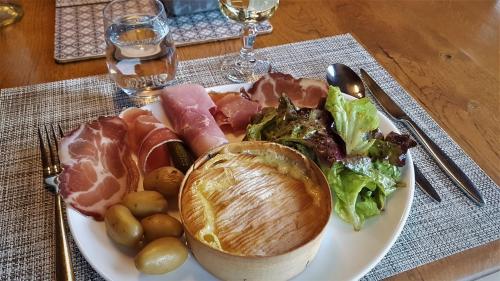 a plate of food with meat and vegetables on a table at "La Coustille" Chambres et Table d'Hôtes in Saint-Léger-les-Mélèzes