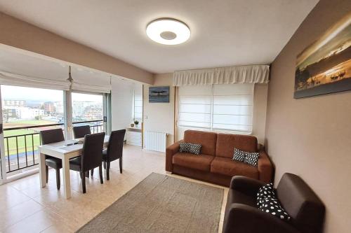 ein Wohnzimmer mit einem Sofa, einem Tisch und Stühlen in der Unterkunft Apartamento en Laredo in Laredo