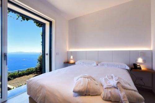a bedroom with a large bed and a large window at Hotel Graal in Ravello