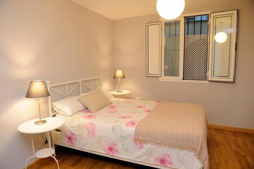 a bedroom with a bed with two tables and two lamps at Apartamento Museo de Bellas Artes in Seville