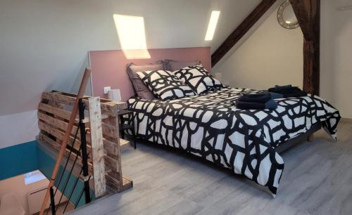 une chambre avec un lit avec une couette noire et blanche dans l'établissement Cosis Colmar - 2 Chambres - 4 Pers - Duplex - Parking - Wifi, à Colmar