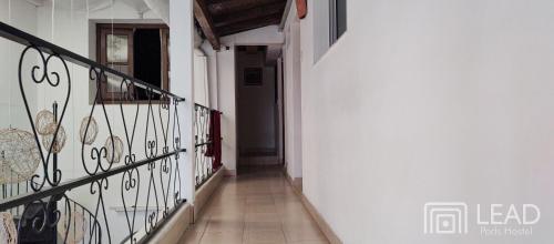 a hallway with a staircase with a wrought iron railing at LEAD Pods Hostel in Salta