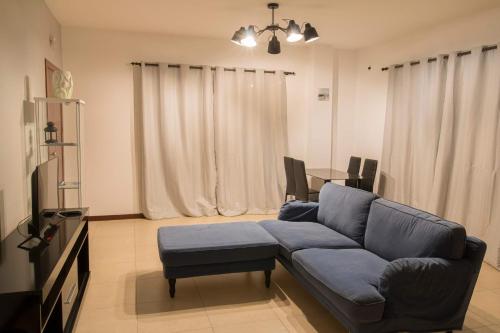 uma sala de estar com um sofá azul e uma mesa em Vannimar Lounge em Porto Novo