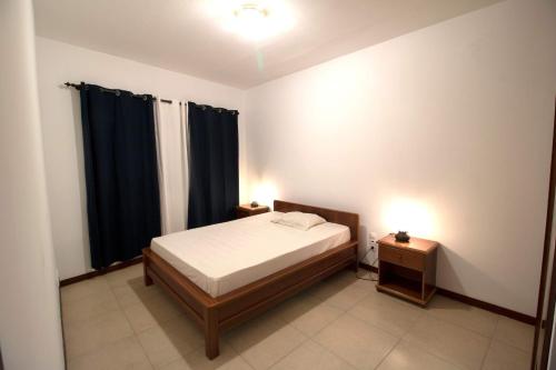 a small bedroom with a bed and a night stand at Vannimar Lounge in Porto Novo