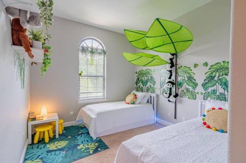 um quarto com 2 camas e um guarda-chuva verde em 3BD Townhouse , Themed , 10 min to Disney , Gated em Kissimmee