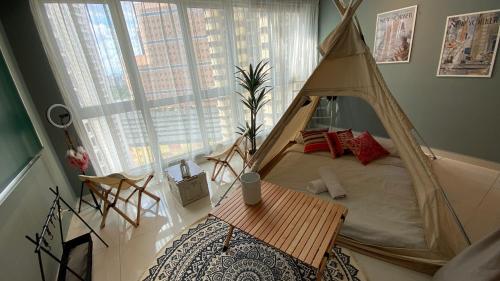 The Infinity Pool+Camping Hideout في كوالالمبور: غرفة نوم مع سرير المظلة وطاولة