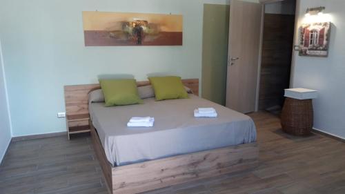um quarto com uma cama com duas almofadas verdes em Villa Gatto Camilla em Rometta Marea