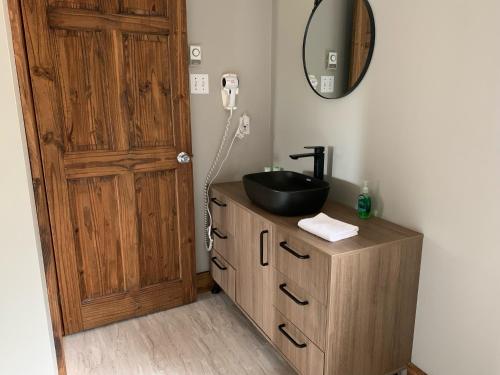 a bathroom with a sink on a wooden dresser with a mirror at Pourvoirie du Lac Blanc in Saint-Alexis-des-Monts