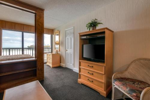 a hotel room with a television and a bedroom at Kingfisher Inn in Myrtle Beach