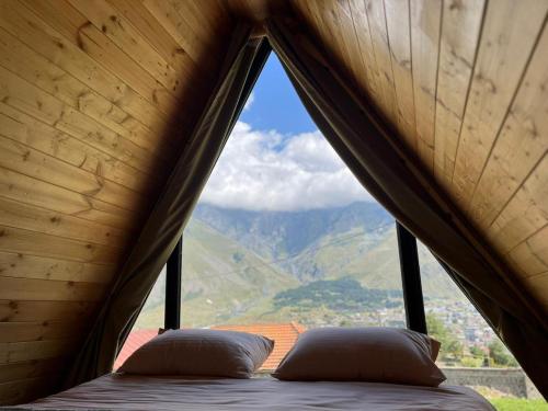 a bed in a tent with a view of a mountain at Cabin 32 in Stepantsminda
