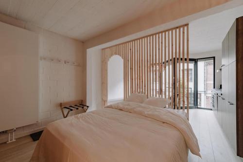 a bedroom with a large bed and a large window at Chimay : La Chambre Blanche de la Grand Place in Chimay