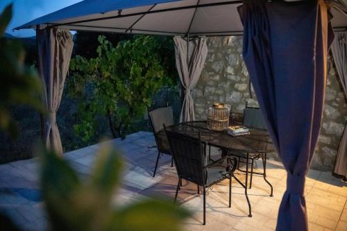 Triantos Guesthome Studio في تريبوليس: طاولة وكراسي مع مظلة على الفناء