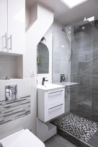 a white bathroom with a shower and a sink at ClickTheFlat Pereca City Centre Apart Rooms in Warsaw