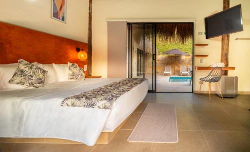 a bedroom with a large bed and a sliding glass door at Hotel Alto de Pajas Boutique by H&R in Villeta