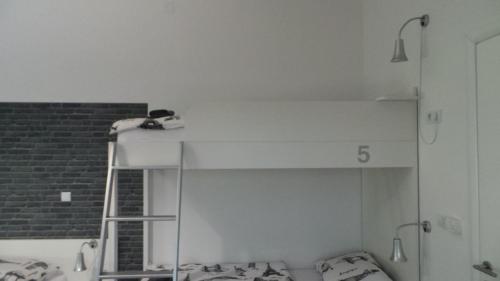 a room with a bunk bed with a ladder at Hostel Levicki in Slavonski Brod