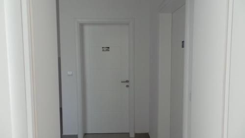 a white door in a room with white walls at Hostel Levicki in Slavonski Brod