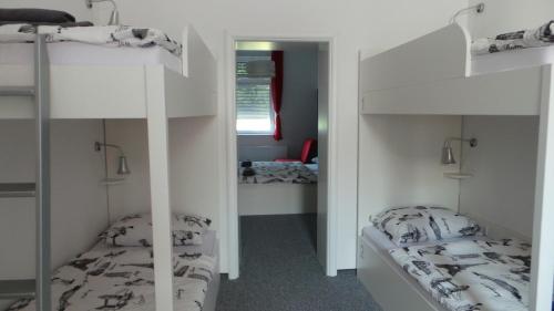 two bunk beds in a room with a mirror at Hostel Levicki in Slavonski Brod