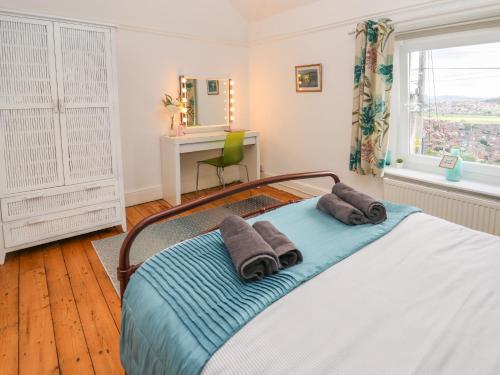 a bedroom with a bed with two towels on it at Euryn View in Llandudno