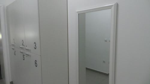 a white cabinet with a mirror in a room at Hostel Levicki in Slavonski Brod
