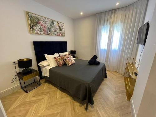 a small bedroom with a bed and a television at Mirador de Sanlucar 9 in Sanlúcar de Barrameda