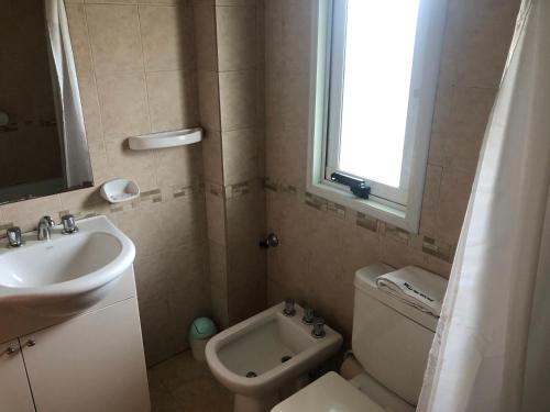 a bathroom with a sink and a toilet and a window at Valle del Molino in Trevelin
