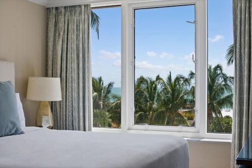 1 dormitorio con ventana grande con vistas al océano en Marco Beach Ocean Suites en Marco Island