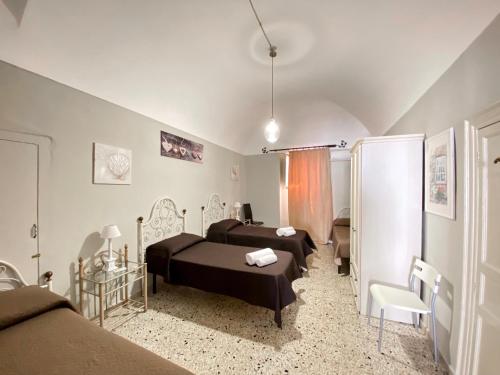 a bedroom with two beds and a bathroom at La Ginestra in Corleone