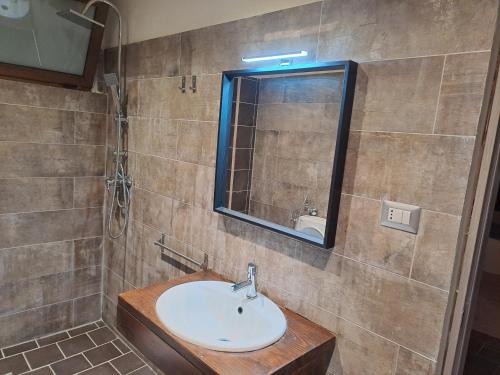 a bathroom with a sink and a mirror at Villa Gatto Alice in Rometta Marea