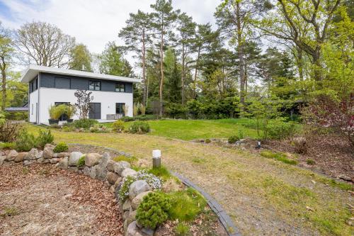 una casa nel bosco con un sentiero in pietra che la porta di Villa-Grenzenlos a Glowe