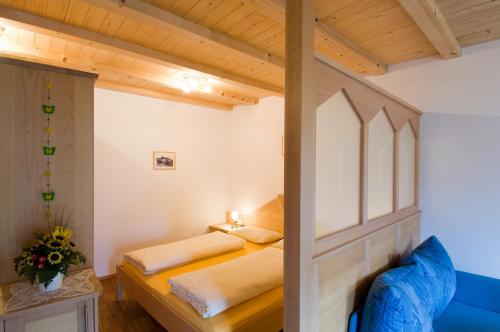 sypialnia z 2 łóżkami i niebieską kanapą w obiekcie Sonnenheimhof w mieście Malles Venosta