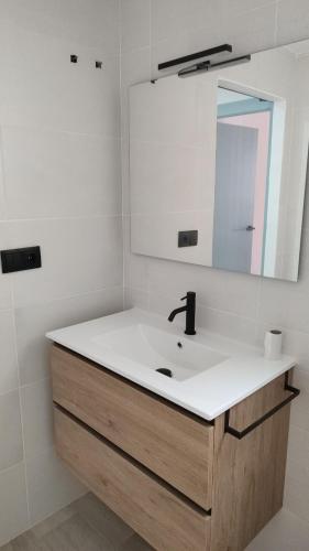 y baño con lavabo y espejo. en Apartamentos las flores en Murcia