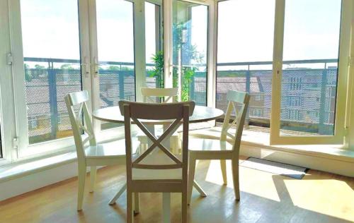 a table and chairs in a room with a large window at Maidenehad Spacious Spectacular and Modern 3 Bedroom 2 Bathroom Penthouse 14 in Maidenhead