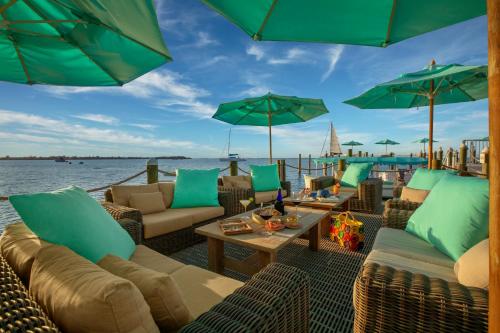 a patio with couches and umbrellas and the water at Bungalows Key Largo - All Inclusive in Key Largo