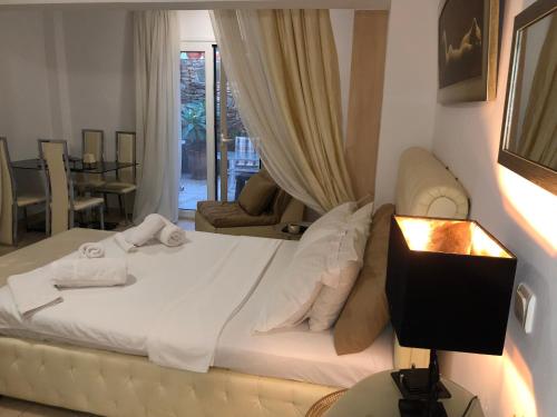 a bedroom with a white bed and a table with a lamp at CALM SUITE in Sitia
