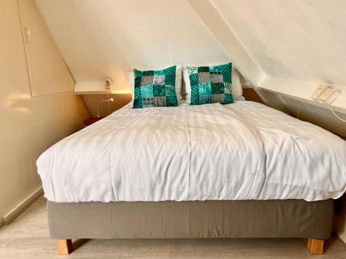 a bedroom with a white bed with blue pillows at Church Square Studio in Zandvoort