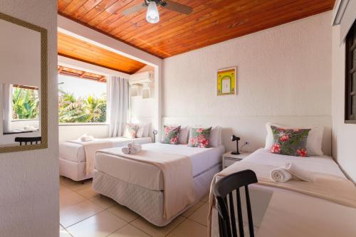 1 dormitorio con 2 camas y ventana en Pousada Recanto do Jabaquara, en Paraty