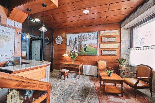 a room with a desk and chairs and a clock at Hotel Entrecercas in Santiago de Compostela