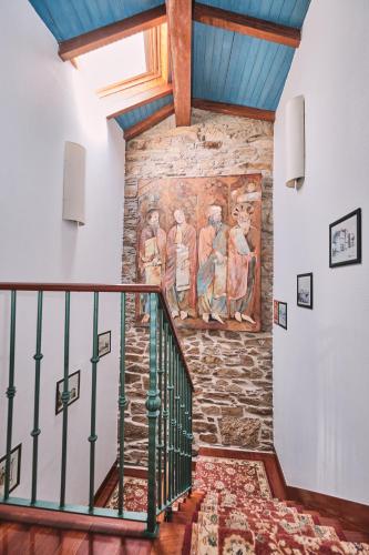 a staircase with a mural on the wall in a house at Hotel Entrecercas in Santiago de Compostela