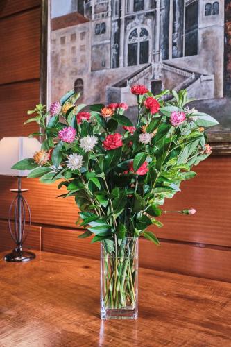 a vase filled with flowers sitting on a table at Hotel Entrecercas in Santiago de Compostela