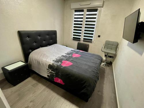 - une chambre avec un lit à tête noire dans l'établissement Ambre&Tiago, à Vaires-sur-Marne