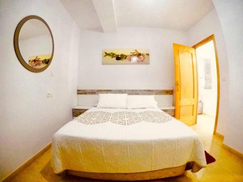 1 dormitorio con cama blanca y espejo en Apartamento Cristian Playa, en Castell de Ferro