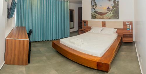 a bedroom with a large bed and a blue curtain at Hotel Rupa Rupa in Tingo María