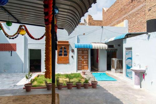 a house with a patio with potted plants at Little prince guest house & homestay in Bikaner